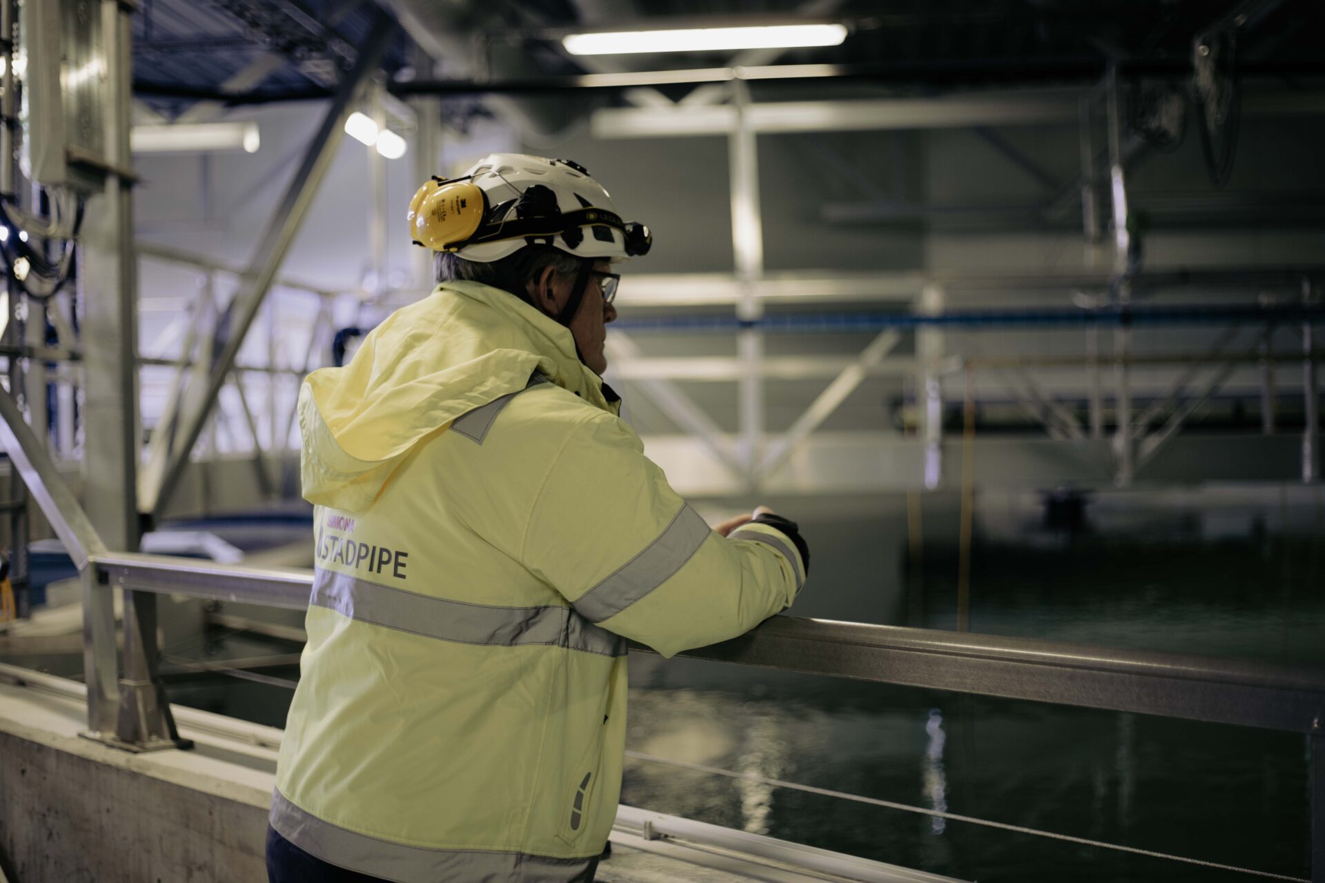 Fagpersonnell på anlegg, ser utover fiskekar